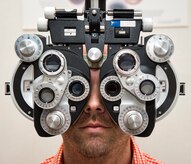 Jason Hale, 628th Medical Group ophthalmic technician, looks through ophthalmic equipment Sep. 9, 2015, at the optometry office on Joint Base Charleston – Air Base, S.C. The optometry clinic provides services such as eye examinations, visual acuity checks, repairing glasses, color vision tests and comprehensive exams. To set up an appointment, call the Air Base optometry clinic at 843-963-6880. (U.S. Air Force photo/Airman 1st Class Clayton Cupit)