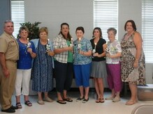 U.S Navy Captain, Tim Sparks, Joint Base Charleston deputy commander (left) and Sheryl Bice, NWCA Eastern Region President (right) installed the new officers of the Navy Wives Clubs of America MenRiv Park #240. Hazel Cole, Gina Kane, Fawn Hersman, Jan Hill, Nancy Tarwarter, and Linda Hedden. 