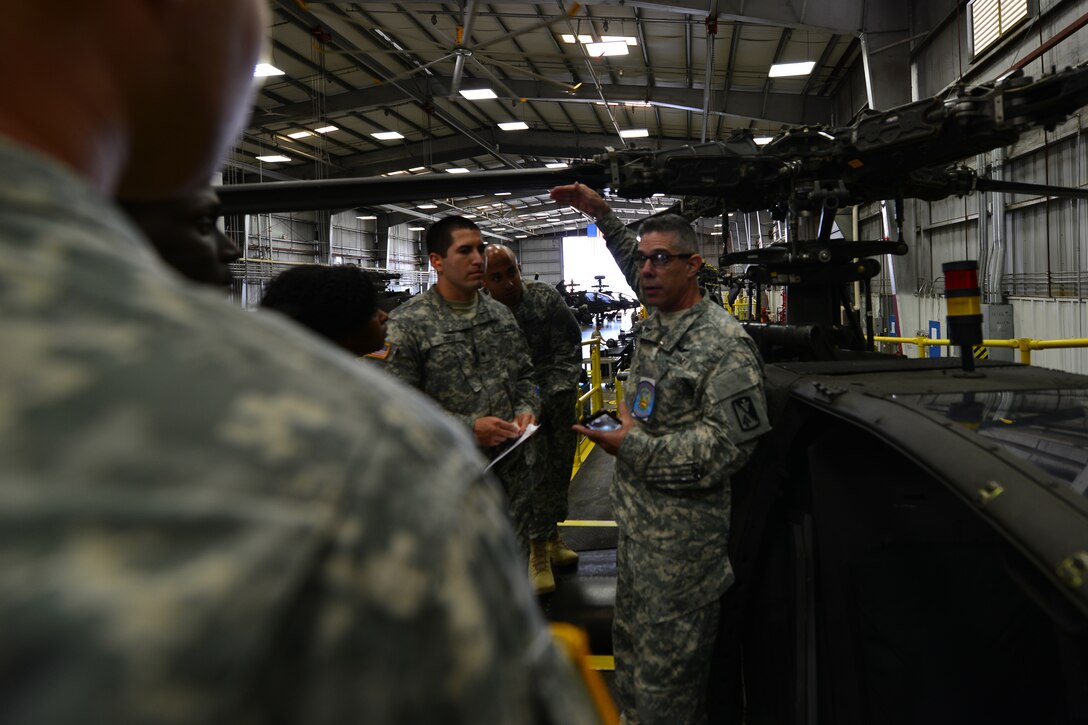 U.S. Army Sgt. 1st Class Victor Wright, Bravo Company, 1st Battalion, 210th Aviation Regiment, 128th Aviation Brigade helicopter maintenance instructor, explains the AH-64D/E Apache helicopter’s abilities during a tour at Fort Eustis, Va., Sept. 3, 2015.  The tour included an overview of the aircraft’s mechanical parts and systems as well as capabilities in supporting U.S. Army missions worldwide. (U.S. Air Force photo by Staff Sgt. Natasha Stannard/Released)