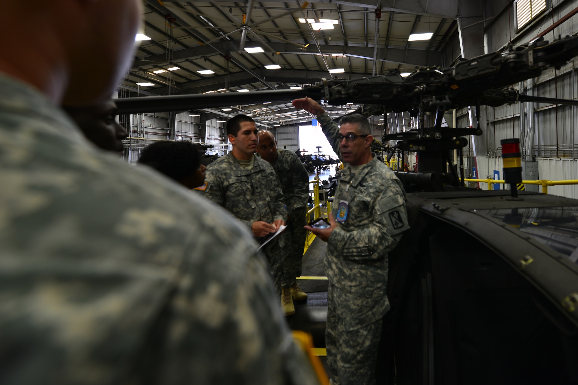 U.S. Army Sgt. 1st Class Victor Wright, Bravo Company, 1st Battalion, 210th Aviation Regiment, 128th Aviation Brigade helicopter maintenance instructor, explains the AH-64D/E Apache helicopter’s abilities during a tour at Fort Eustis, Va., Sept. 3, 2015.  The tour included an overview of the aircraft’s mechanical parts and systems as well as capabilities in supporting U.S. Army missions worldwide. (U.S. Air Force photo by Staff Sgt. Natasha Stannard/Released)