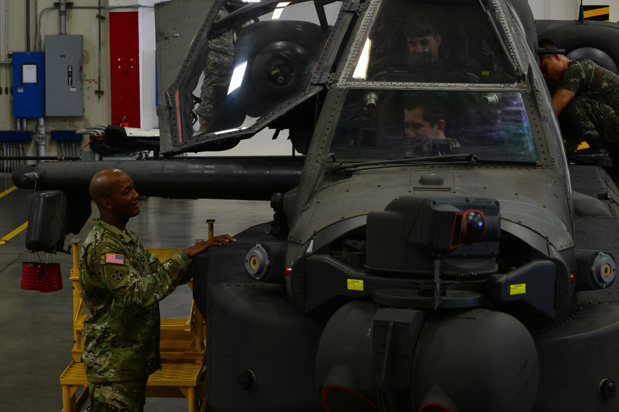 U.S. Army Capt. Wayne E. Griffin Jr., Bravo Company, 1st Battalion, 210th Aviation Regiment, 128th Aviation Brigade commander, speaks with members of the U.S. Army Public Health Command Fort Eustis Branch about piloting an AH-64D/E Apache helicopter during a tour at Fort Eustis, Va., Sept. 3, 2015. The company and branch conducted a tour together to gain understanding of what they all accomplish for Joint Base Langley-Eustis missions. (U.S. Air Force photo by Staff Sgt. Natasha Stannard/Released)