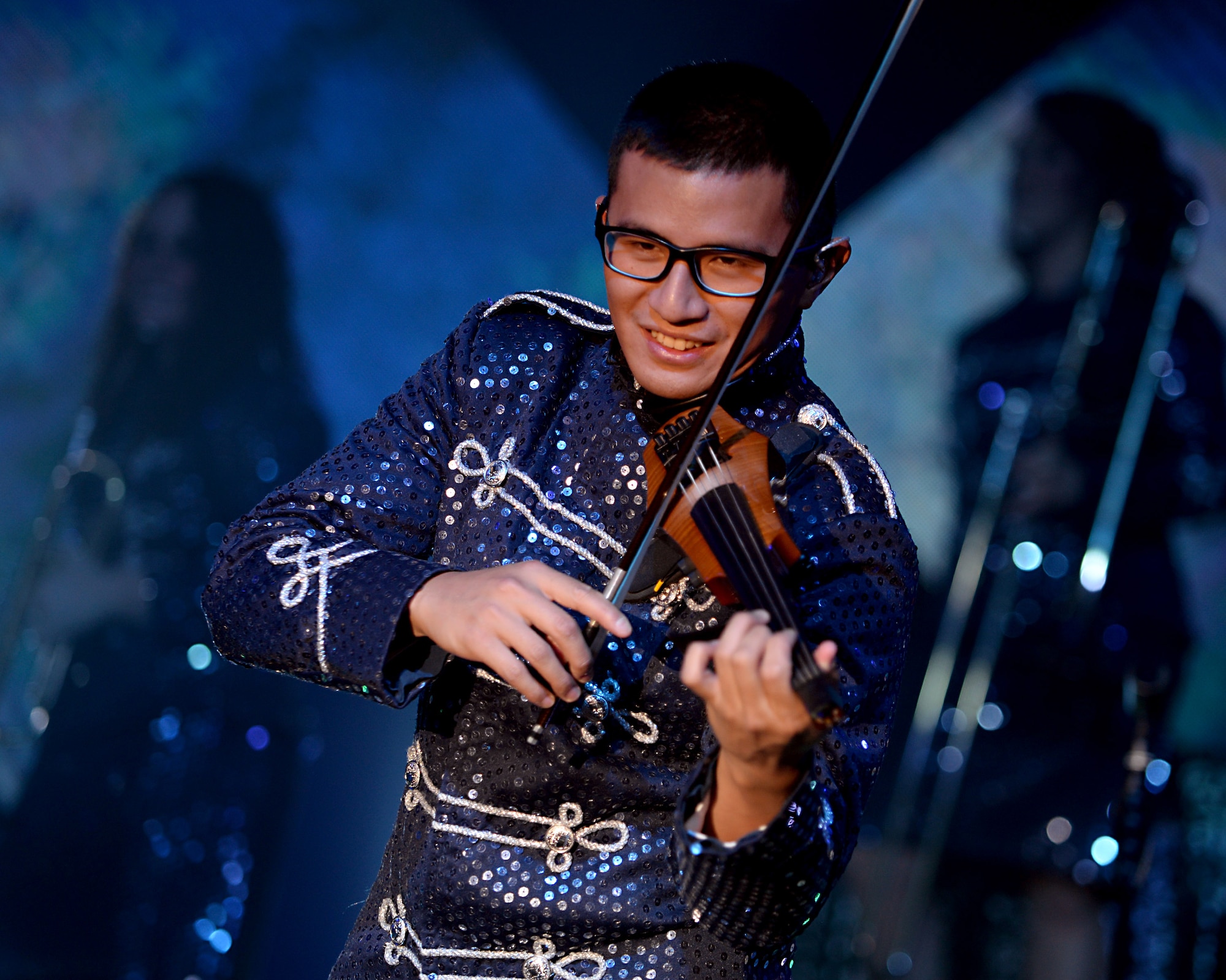 U.S. Air Force 1st Lt. Oliver Chang, Space and Missile Systems Center developmental engineer from Los Angeles Air Force Base, Cali., performs with his violin during a Tops in Blue performance at the Northside Fitness Center Sept. 4, 2015, on RAF Mildenhall, England. The group consists of vocalist, instrumentalists and technicians. (U.S. Air Force photo by Senior Airman Christine Halan/Released) 