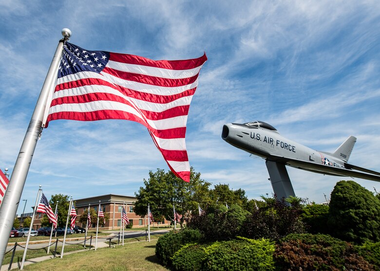 United States flags fly around the F-86 static display on base Sept. 9. Traditional guidelines call for displaying the flag in public only from sunrise to sunset. However, the flag may be displayed at all times if it’s illuminated during darkness. (U.S. Air Force photo by Mark Herlihy)