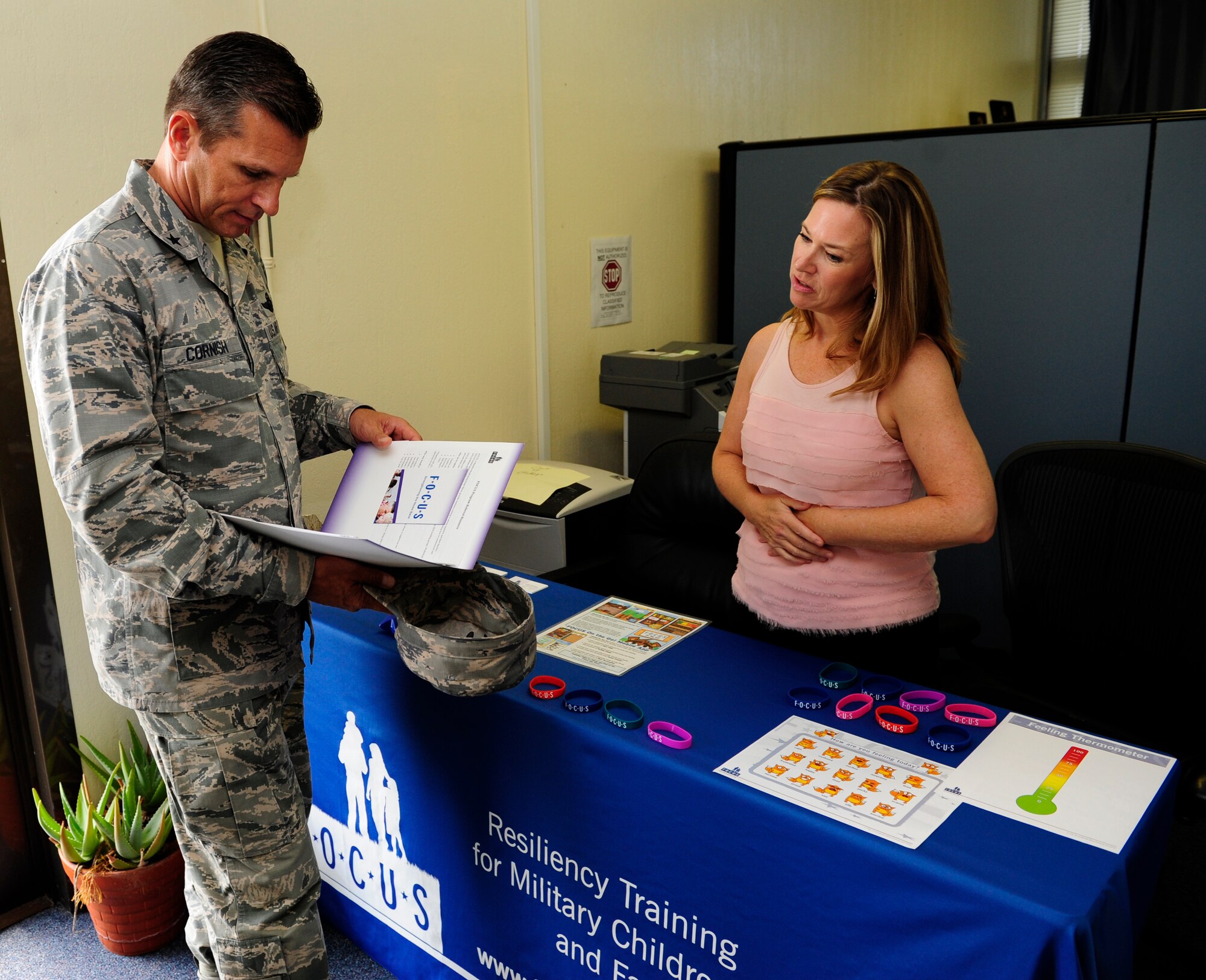 Stacy Roark, family resiliency trainer, discusses the Families OverComing Under Stress program with Brig. Gen. Barry Cornish, 18th Wing commander, in support of Project 22, Sept. 9, 2015, at Kadena Air Base, Japan. FOCUS provides families with resiliency training to help them overcome the stressors that come with being in the military. (U.S. Air Force Photo by Airman 1st Class Corey M. Pettis)