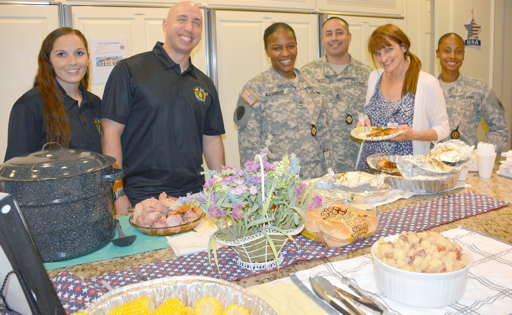 Sgt. Audie Murphy Club members (from left) Staff. Sgt. Amy Davis, president, Sgt. Audie Murphy Club; Sgt. 1st Class Justin Puls; Sgt. 1st Class Ebony Alexander; Sgt. 1st Class Rommel Fuentes; and Staff Sgt. Lekita Singleton, pose with a Fisher House resident who came by to pick up  some food provided by the club members for the residents. “We try to do this event semi-annually and we do it as a way to repay the families for their service and to appreciate what they are doing,” Davis said.