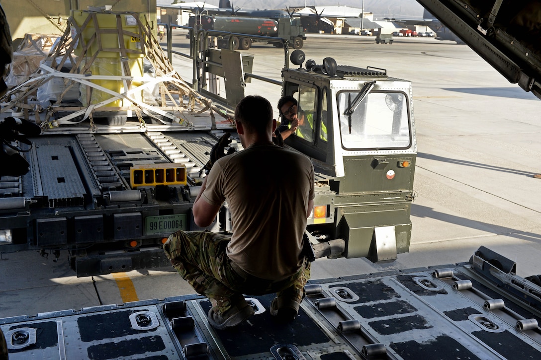 U.S. Air Force Staff Sgt. Casey Strauss directs a truck as its moves cargo onto a C-130J Super Hercules aircraft at Bagram Airfield, Afghanistan, Aug. 28, 2015. Strauss is a loadmaster assigned to the 774th Expeditionary Airlift Squadron. U.S. Air Force photo by Senior Airman Cierra Presentado
