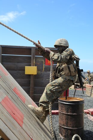 Private Chris M. Gitau, Golf Company, 2nd Recruit Training Battalion, climbs a wall while avoiding red marked areas during the Crucible 12 Stalls event at Edson Range, Camp Pendleton, Calif., Sept. 2.  Each stall consisted of a specific task the squads needed to accomplish.  If a recruit or the object he was moving touched the red area, which was considered an Improvised Explosive Device trigger, he was required to run with two 30-pound ammunition cans for approximately 50 yards.  Gitau a Nairobi, Kenya, native, moved to America at the age of 21 and was inspired by his cousin to join the Marine Corps.  Today, all males recruited from west of the Mississippi are trained at MCRD San Diego. The depot is responsible for training more than 16,000 recruits annually. Golf Company graduated Sept. 11.