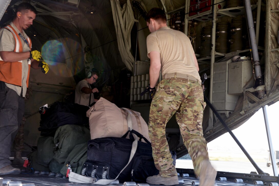 U.S. Air Force Staff Sgt. Casey Strauss, right, moves luggage onto a C-130J Super Hercules aircraft at Bagram Airfield, Afghanistan, Aug. 28, 2015. Strauss is a loadmaster assigned to the 774th Expeditionary Airlift Squadron. U.S. Air Force photo by Senior Airman Cierra Presentado