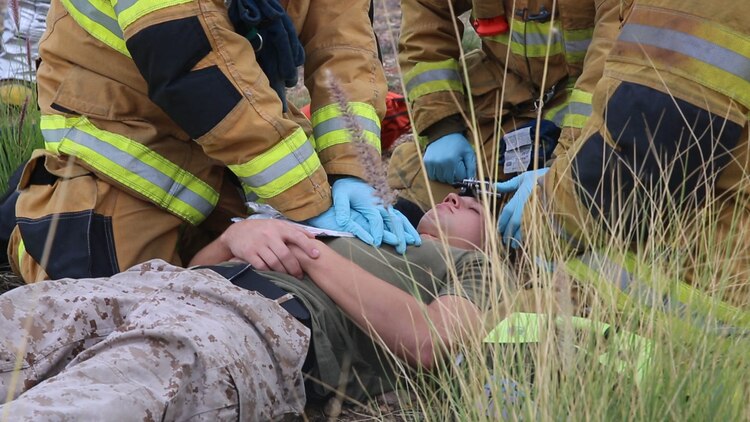 Firefighters stationed at Marine Corps Air Station Miramar, California, perform first aid on a simulated crash victim during an aircraft mishap response exercise aboard the air station, Sept. 3. The aircraft mishap response exercise required Marine and civilian firefighters aboard the installation to both extinguish simulated aircraft fires and provide aid to simulated crash victims.