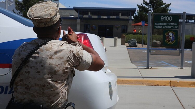 Cpl. Desean White, a military police officer stationed with the Provost Marshal’s Office, posts behind his vehicle during an active shooter response exercise at Marine Corps Air Station Miramar, California, Sept. 2. Military and civilian police worked together during the exercise as part of required annual safety training.