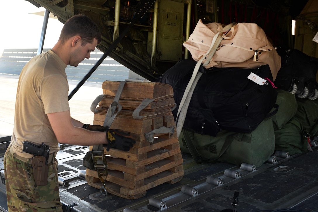 U.S. Air Force Staff Sgt. Casey Strauss secures cargo onto a C-130J Super Hercules aircraft at Bagram Airfield, Afghanistan, Aug. 28, 2015. Strauss is a loadmaster assigned to the 774th Expeditionary Airlift Squadron. U.S. Air Force photo by Senior Airman Cierra Presentado