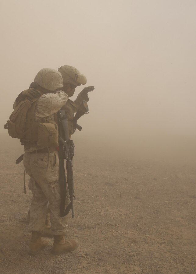 Marines with Combat Logistics Battalion 1, Combat Logistics Regiment 1, 1st Marine Logistics Group, shield their faces from sand blown by a CH-53E Super Stallion during a simulated casualty evacuation aboard Marine Corps Air Ground Combat Center Twentynine Palms, California, Aug. 10, 2015. The training prepared Marines for future Special Purpose Marine Air Ground Task Force operations and Large Scale Exercise 15, a combined U.S. Marine Corps, Canadian and British exercise.