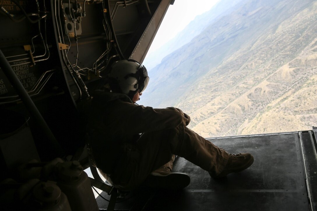 A crew chief with Marine Medium Tiltrotor Squadron 764 observes the outskirts of the Phoenix cityscape from the bay of an MV-22B Osprey during an orientation flight held for community leaders and influencers during Marine Week Phoenix, Sept. 9, 2015. Marine Week Phoenix is an opportunity for the people of the greater Phoenix area to meet Marines and learn about Corps history, traditions, and value to the nation. (USMC photo by Pfc. Devan K. Gowans/Released)