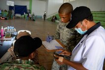 Airman 1st Class Lance Easter, 36th Medical Operations Squadron medical technican, assists a soldier with the Falintil Forças de Defesa de Timor-Leste record patient data during an Operation Pacific Angel 15-2 health services outreach, Sept. 7, 2015, in Baucau, Timor-Leste. Angel is a multilateral humanitarian assistance civil military operation, which improves military-to-military partnerships in the Pacific while also providing medical health outreach, civic engineering projects and subject matter exchanges among partner forces. (U.S. Air Force photo by Staff Sgt. Alexander W. Riedel/Released)