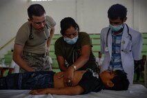 U.S. Air Force Maj. (Dr.) Richard Trowbridge family practice physician assigned to the 374th Medical Group at Yokota Air Base, Japan, examines a young boy with Falintil-Forças de Defesa de Timor-Leste 2nd Lt. (Dr.) Anabela de Cruz, during  an Operation Pacific Angel 15-2 health services outreach clinic Sept. 7, 2015, in Baucau, Timor-Leste. Pacific Angel is a multilateral humanitarian assistance civil military operation, which improves military-to-military partnerships in the Pacific while also providing medical health outreach, civic engineering projects and subject matter exchanges among partner forces. (U.S. Air Force photo by Staff Sgt. Alexander W. Riedel/Released)