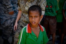 A student of the Al-Amal primary school watches a rice donation to the neighbouring orphanage by Pacific Angel 15-2 team members Sept. 8, 2015, in Baucau, Timor-Leste. Efforts undertaken during Pacific Angel help multilateral militaries in the Pacific improve and build relationships across a wide spectrum of civic operations, which bolsters each nation’s capacity to respond and support future humanitarian assistance and disaster relief operations. (U.S. Air Force photo/Staff Sgt. Alexander W. Riedel/Released)