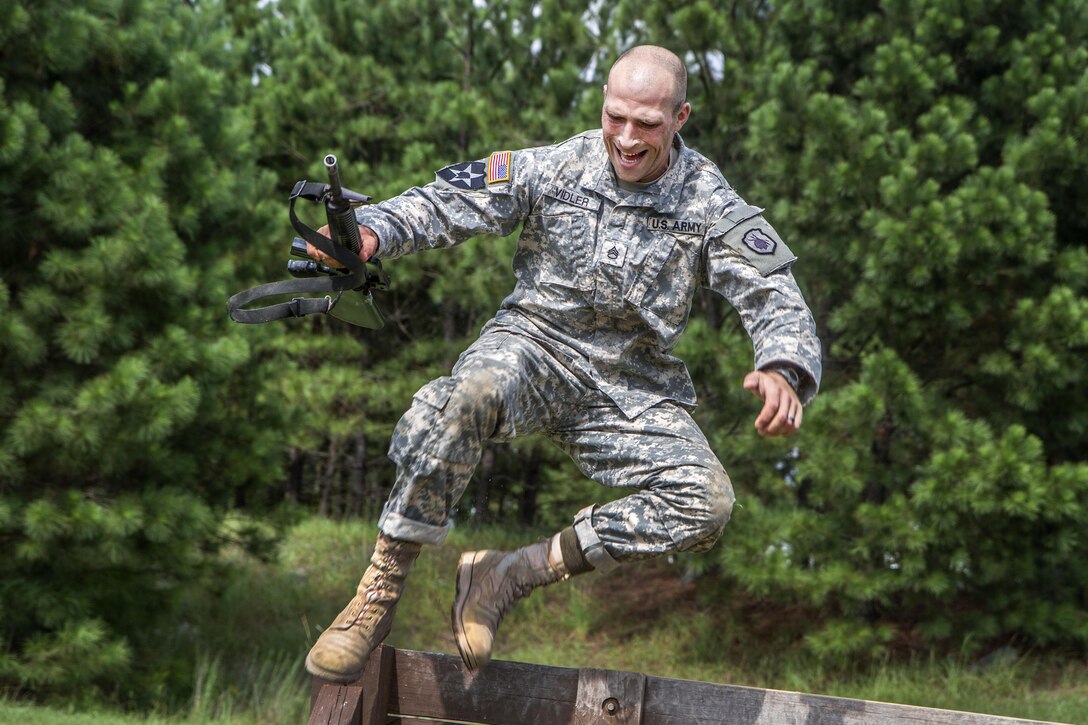 Army Staff Sgt. Russell Vidler leaps over the wall at the Fit to Win obstacle course on Fort Jackson, S.C., Sept. 9, 2015. Vidler, a Reserve drill sergeant assigned to the 98th Training Division, was in a head-to-head competition for the title of Army Reserve's top drill sergeant. U.S. Army photo by Sgt. 1st Class Brian Hamilton