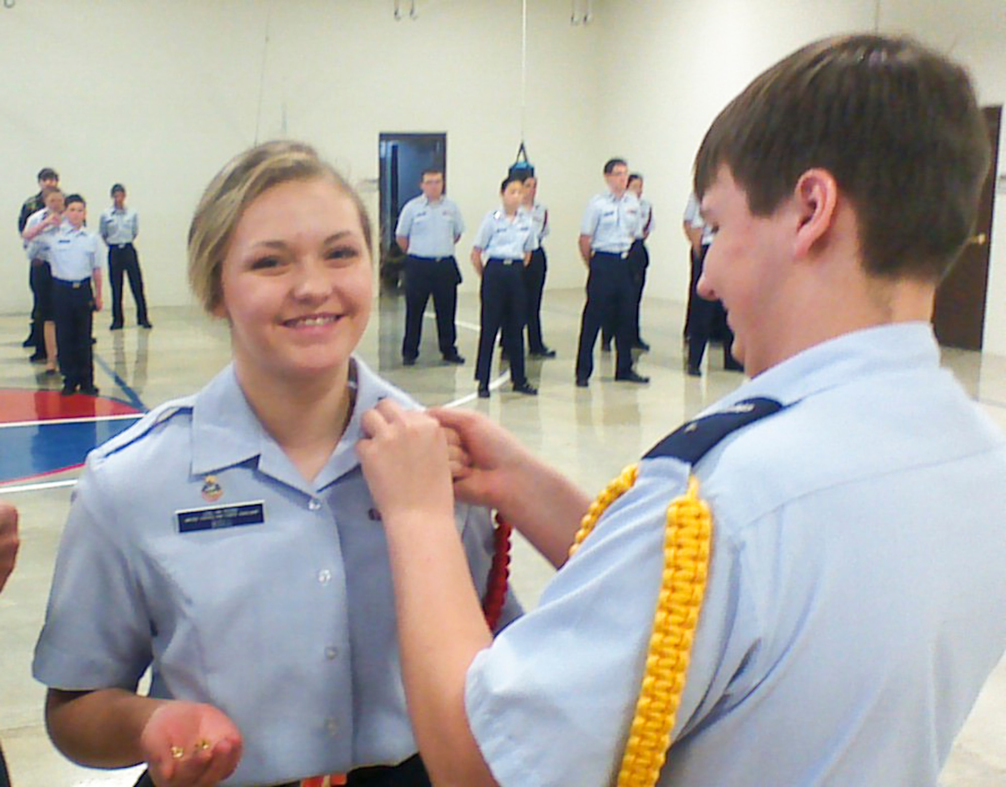 One Wyoming Civil Air Patrol cadet pins an insignia on the collar of another cadet during Operation White Stripe, a training event for CAP cadets from March 20 to 22, 2015 in Casper, Wyo. CAP volunteers working as Air Force auxiliaries were recently recognized by the Air Force as part of the Total Force and were given the designation of “Airmen.” (Courtesy photo)