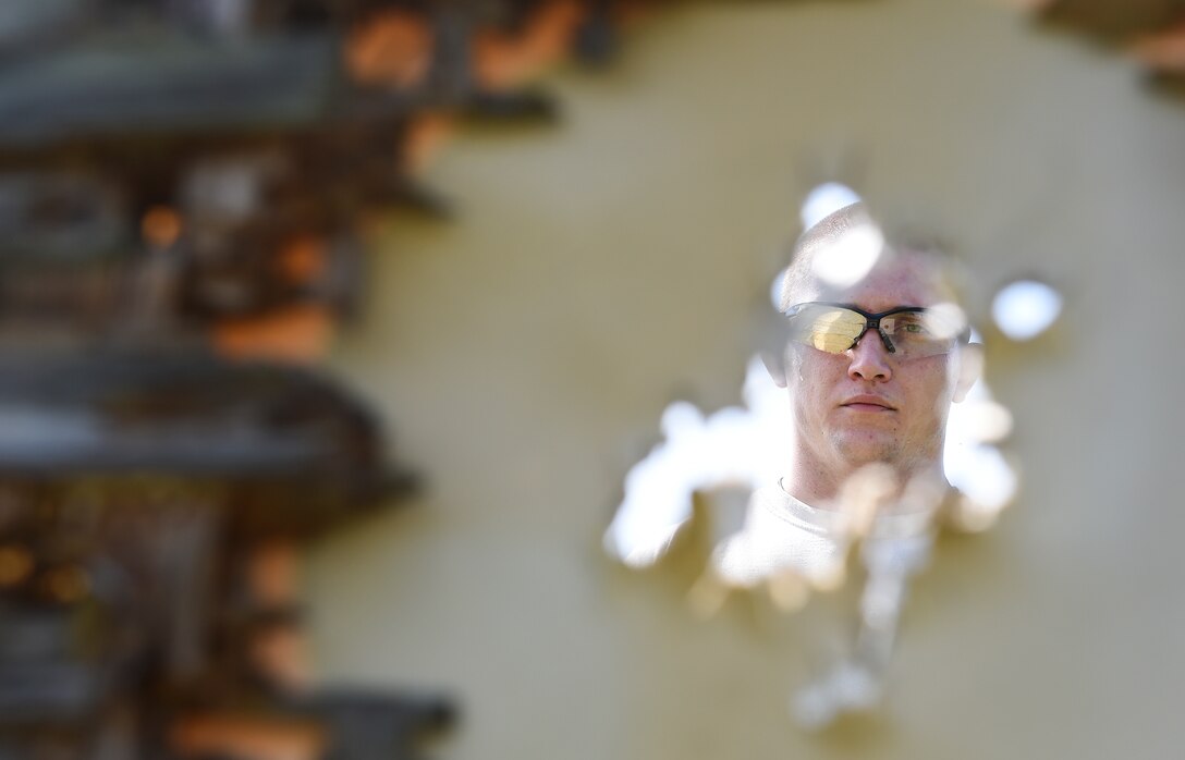U.S. Air Force Staff Sgt. Jeremiah Jackson, 23d Equipment Maintenance Squadron aircraft metal technology craftsman and member of the Air Force National Pistol Team, approaches his target during pistol shooting practice Sept. 4, 2015, in Valdosta Ga. He placed first out of all Air Force shooters, second out of all the service members in his category and 13th out of 627 of all the national competitors during the National Rifle Association National Pistol Championship held July 6-10. (U.S. Air Force photo by Senior Airman Ceaira Tinsley/Released)