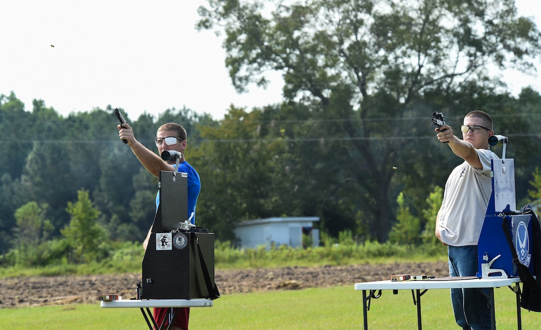 U.S. Air Force Staff Sgt. Jeremiah Jackson, (right), 23d Equipment Maintenance Squadron aircraft metals technology craftsman, and Senior Airman Ian Pitts, 23d EMS munitions flightline delivery crew chief, fire their .45-caliber pistols during pistol shooting practice Sept. 4, 2015, in Valdosta, Ga. Jackson and Pitts practice two to three times a week and compete twice monthly to keep their pistol techniques sharp and assist Pitts in becoming a part of the Air Force National Pistol Team. (U.S. Air Force photo by Senior Airman Ceaira Tinsley/Released)