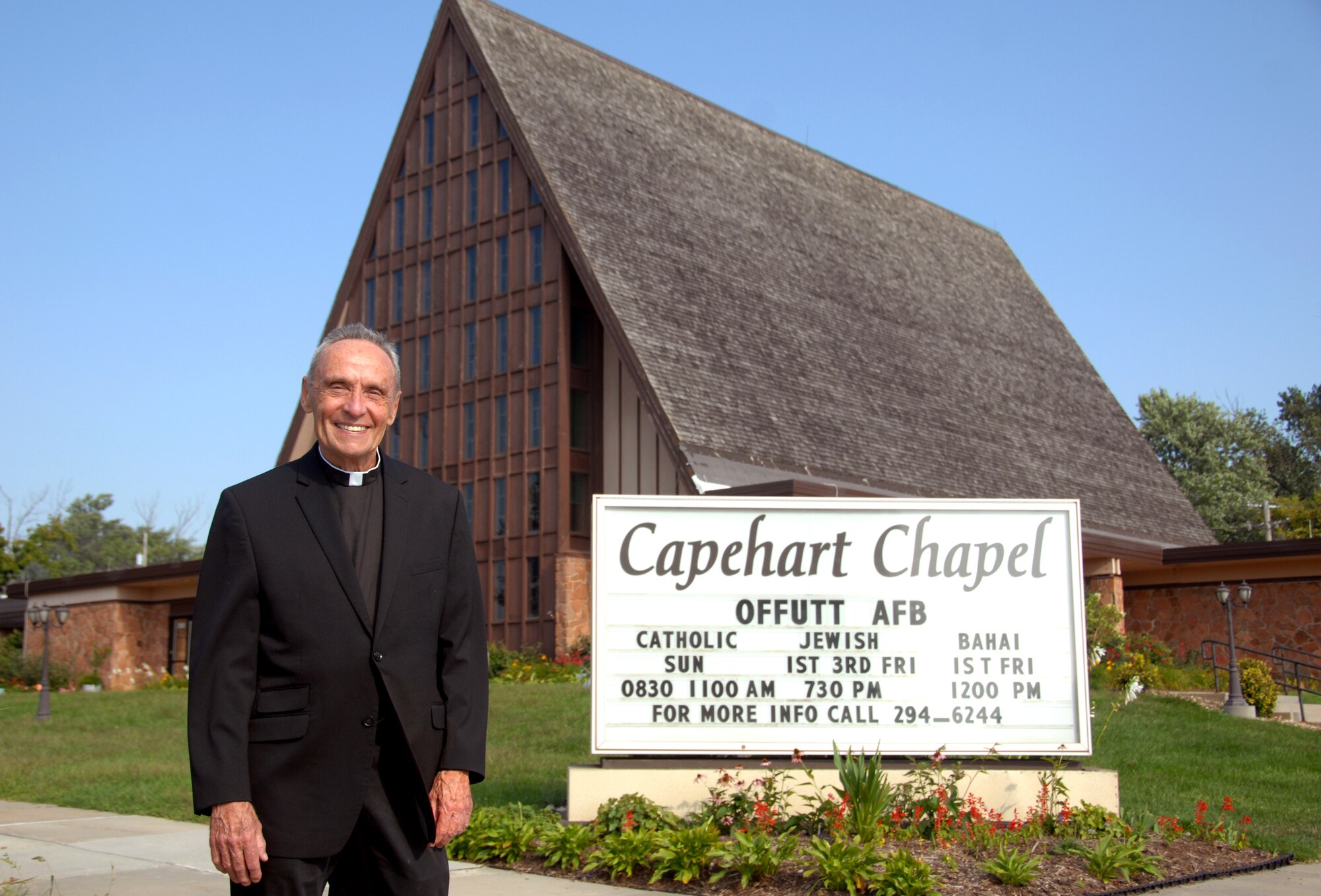 The Rev. Bernard Byrne, who goes by “Father Bernie,” poses for a photo outside the Capehart chapel at Offutt Air Force Base, Neb. Sept. 2. Byrne is the new Catholic priest for Offutt and will conduct Catholic Mass and services for members of Team Offutt. (U.S. Air Force photo by Delanie Stafford/Released)