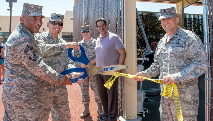 (From left to right) Chief Master Sgt. Christopher Toney, 60th Force Support Squadron, superintendent, and Lt. Col. John Cappella Zielinski, 60th FSS commander, Chief Master Sgt. Alan Boling, 60th Air Mobility Wing command chief,  Mr. Dean Fazzio, Fitness Center director and Lt. Col. Michael Tiemann, Mission Support Group deputy commander, cut the ribbon Sept. 8 opening The Jungle at Travis Air Force Base, California, 2015. (U.S. Air Force Photograph by Heide Couch)