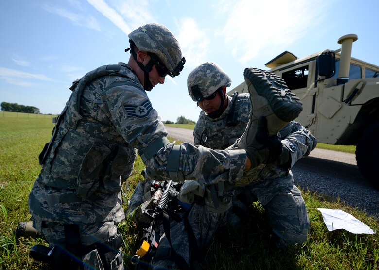 Staff Sergeants Stephen Canyon, left, and Caleb Maupin, 22nd Security Forces Squadron patrolmen, treat a fellow Defender’s simulated wounds during a training exercise, Sept. 3, 2015, at McConnell Air Force Base, Kan. The exercise covered multiple scenarios that could happen during a deployment, including handling casualties after firefights with enemy forces. (U.S. Air Force photo by Senior Airman Victor J. Caputo)