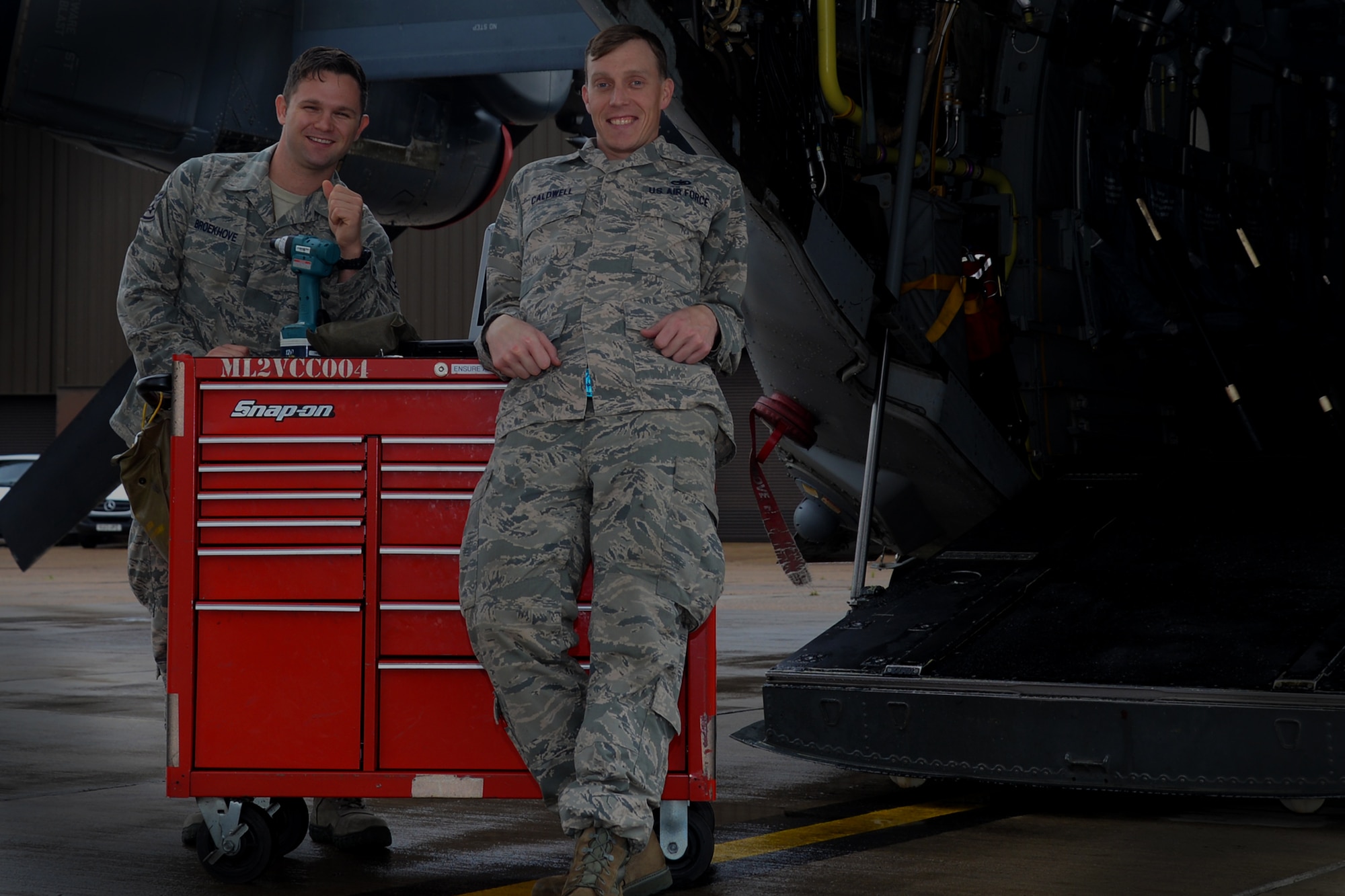 U.S. Air Force Staff Sgt. Blake Broekhove, left, and U.S. Air Force Staff Sgt. Scott Caldwell, 352nd Special Operations Maintenance Squadron CV-22 Osprey crew chiefs, stand near a CV-22 while on the flightline Sept. 1, 2015, on RAF Mildenhall, England. Caldwell and Broekhove put their military training skills to work Aug. 15, 2015, by performing CPR as a team on an injured community member. (U.S. Air Force photo by Senior Airman Victoria H. Taylor/Released)