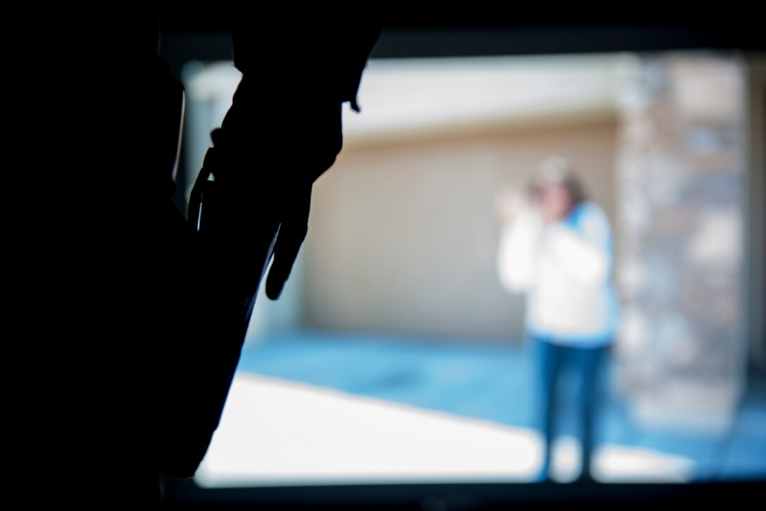 An 11th Security Forces Squadron member prepares to unholster his modified M9 during a simulated projection exercise at the 11 SFS training building on Joint Base Andrews, Md., Sept. 3, 2015. The course and system is there to build confidence in use of force scenarios.  (U.S. Air Force photo by Airman 1st Class Philip Bryant/Released)