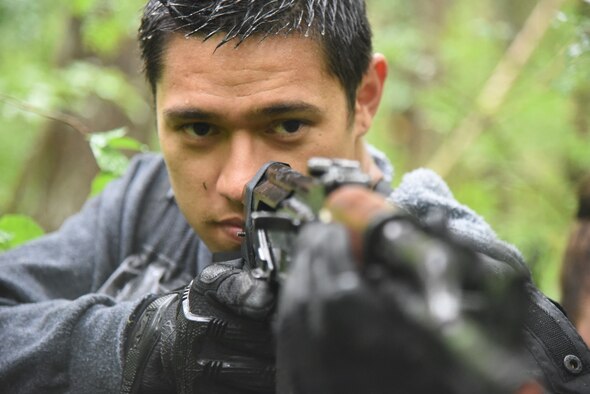 Civilian Matthew Dye, 14th Fighter Squadron unit program coordinator, looks down the sight of his simulated AK-47 rifle during a combat survival training exercise at Draughon Range, Japan, Sept. 9, 2015. Dye was assigned the role of enemy combatant and his mission was to hunt pilots who had egressed into his territory. Upwards of 30 role-players are used for CSTs as friendly civilians or enemy combatant. (U.S. Air Force photo by Senior Airman Patrick S. Ciccarone/Released)