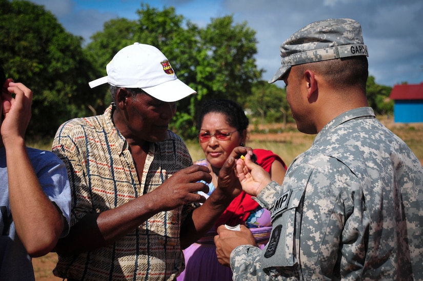 TRUJILLO, Honduras – U.S. Army Spc. Yiovany Garcia, Joint Security Forces patrolman, rolls a foam earplug for a gentleman preparing to board a Joint Task Force-Bravo helicopter for a flight from Puerto Lempira to Trujillo, Honduras, Aug. 27, 2015. JTF-Bravo teamed with the Government of Honduras to transport 25 patients needing eye care to Trujillo, as part of Continuing Promise 2015, a U.S. Southern Command-sponsored exercise that builds partnership with nations throughout Central and South America and the Caribbean. (U.S. Air Force photo by Capt. Christopher Love)