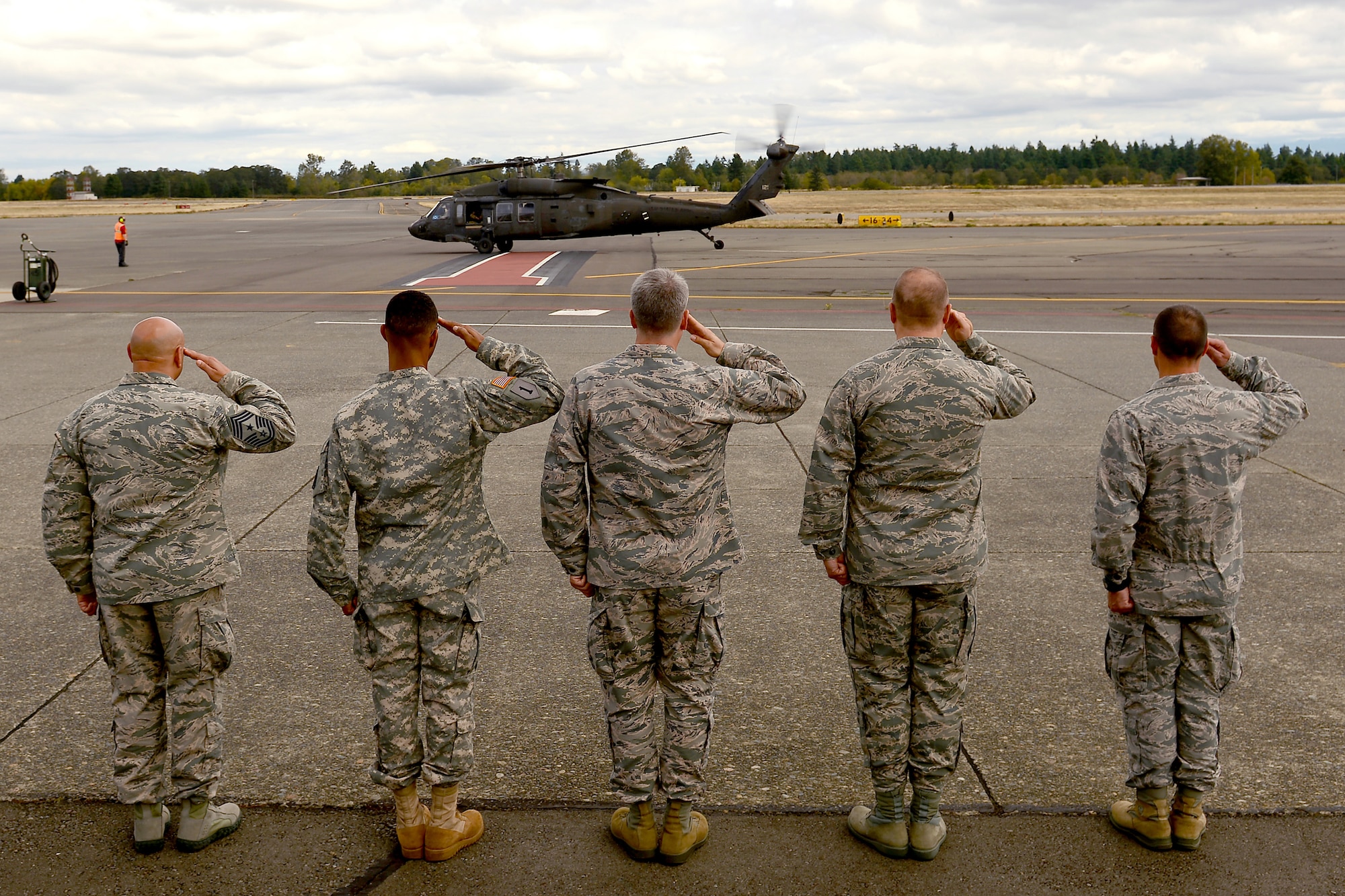 Leadership from Joint Base Lewis-McChord salute the arrival of Admiral Harry B. Harris Jr., Pacific Command commander, Sept. 8, 2015, to McChord Field, Wash. PACOM overseas the operations of the Army, Navy, Air Force and Marines within its area of responsibility, and area that covers more geographical area than any of the other five combatant commands around the globe. (U.S. Air Force photo/Staff Sgt. Tim Chacon)