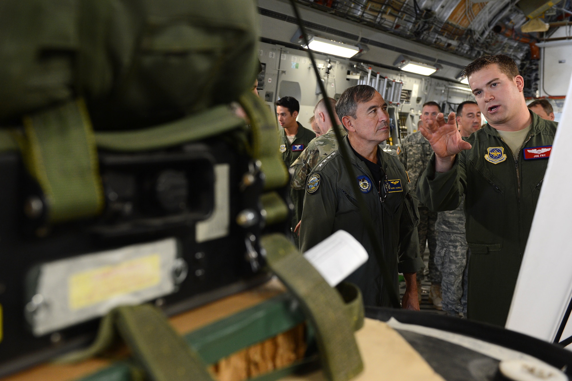 Capt. Joe Fry (right), 62nd Airlift Wing C-17 pilot, briefs Admiral Harry B. Harris Jr., Pacific Command commander, Sept. 8, 2015, at Joint Base Lewis-McChord, Wash. Fry explained the details of air drop operations. (U.S. Air Force photo/Staff Sgt. Tim Chacon)