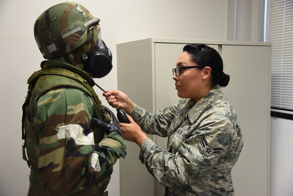 U.S. Air Force Airman 1st Class Joanna Lopez, 35th Civil Engineer Squadron emergency management logistics journeyman, inserts a spray device into an Airman’s mission oriented protective posture gear at Misawa Air Base, Japan, Sept. 10, 2015. The spray device contains a lesser-strength version of tear gas. Lopez often conducts chemical, biological, radiological and nuclear equipment tests, ensuring preparedness during disaster situations. (U.S. Air Force photo by Senior Airman Patrick S. Ciccarone/Released)