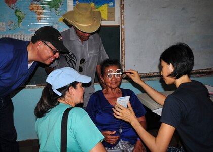 TRUJILLO, Honduras – Angela Brauman, a patient from the remote department of Gracias a Dios in eastern Honduras, receives an eye exam from U.S. Navy Lt. Serena Leung, U.S.N.S. Comfort optomologist, during Continuing Promise 2015 in Trujillo, Honduras, Aug. 28, 2015. Leung and Brauman communicated with the help of two separate translators, passing from English to Spanish to Misquito and back. (U.S. Air Force photo by Capt. Christopher Love)