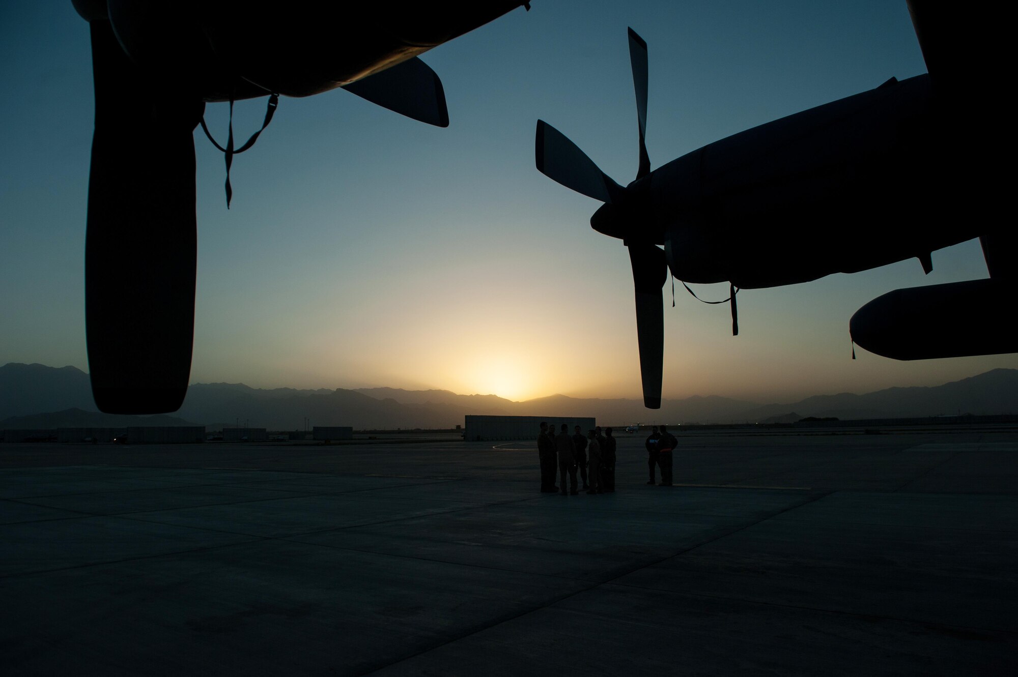 U.S. Airmen assigned to the 41st Expeditionary Electronic Combat Squadron talk during an EC-130H Compass Call aircraft final mission meeting on the flight line at Bagram Airfield, Afghanistan, Sept. 6, 2015.  The Compass Call is an airborne tactical weapon system using a heavily modified version of the C-130 Hercules airframe. (U.S. Air Force photo by Tech. Sgt. Joseph Swafford/Released)