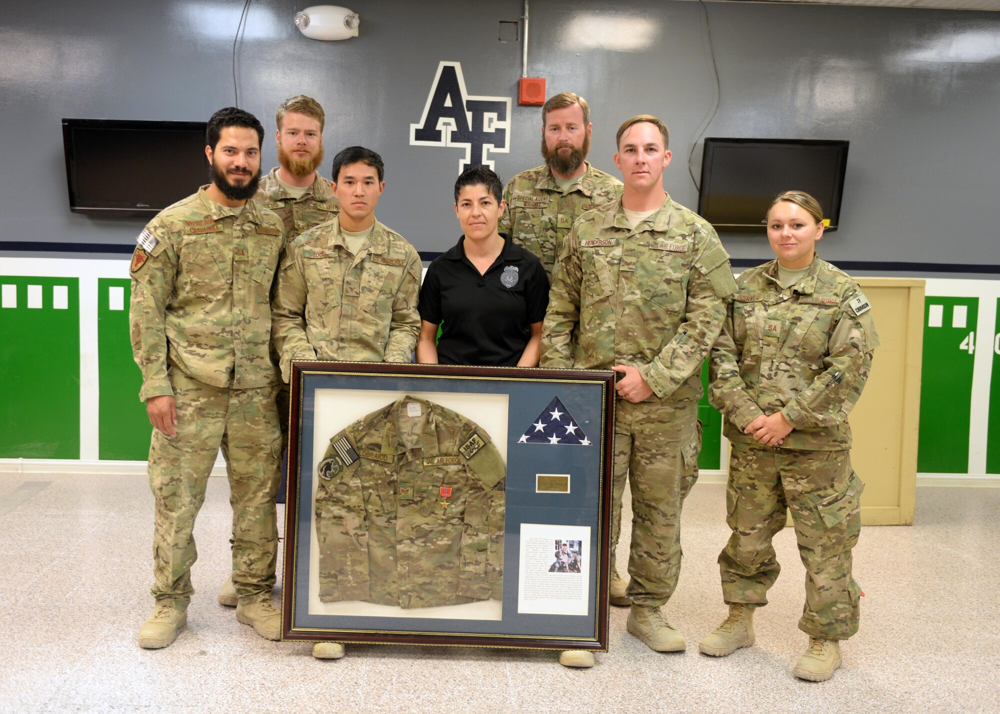 Members of the Task Force Crimson expeditionary detachment 2405, pose for a photo with a shadowbox dedicated to fallen hero Staff Sgt. Todd Lobraico after a dedication remembrance ceremony Sep. 5, 2015, at Bagram Airfield, Afghanistan. Members of BAF gathered to remember the sacrifice made by Lobraico when he lost his life during a fire fight against enemy forces while deployed here in 2013. (U.S. Air Force photo by Senior Airman Cierra Presentado/Released)  