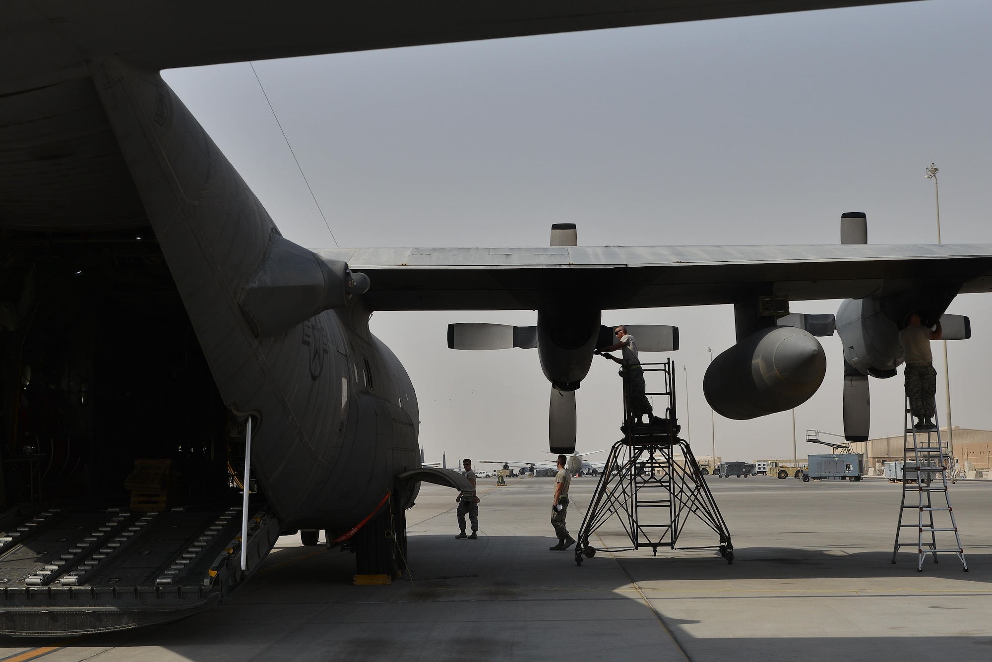 Airmen from the 379th Expeditionary Aircraft Maintenance Squadron, 746th Expeditionary 
Aircraft Maintenance Unit communicate with each other and follow their technical orders to ensure that the C-130 Hercules is in flying condition after their inspection and maintenance September 9, 2015 at Al Udeid Air Base, Qatar. The 746th AMU airmen are responsible for ensuring aircraft are maintained to exact standards to support Operation Inherent Resolve. (U.S. Air Force photo/Staff Sgt. Alexandre Montes)  
