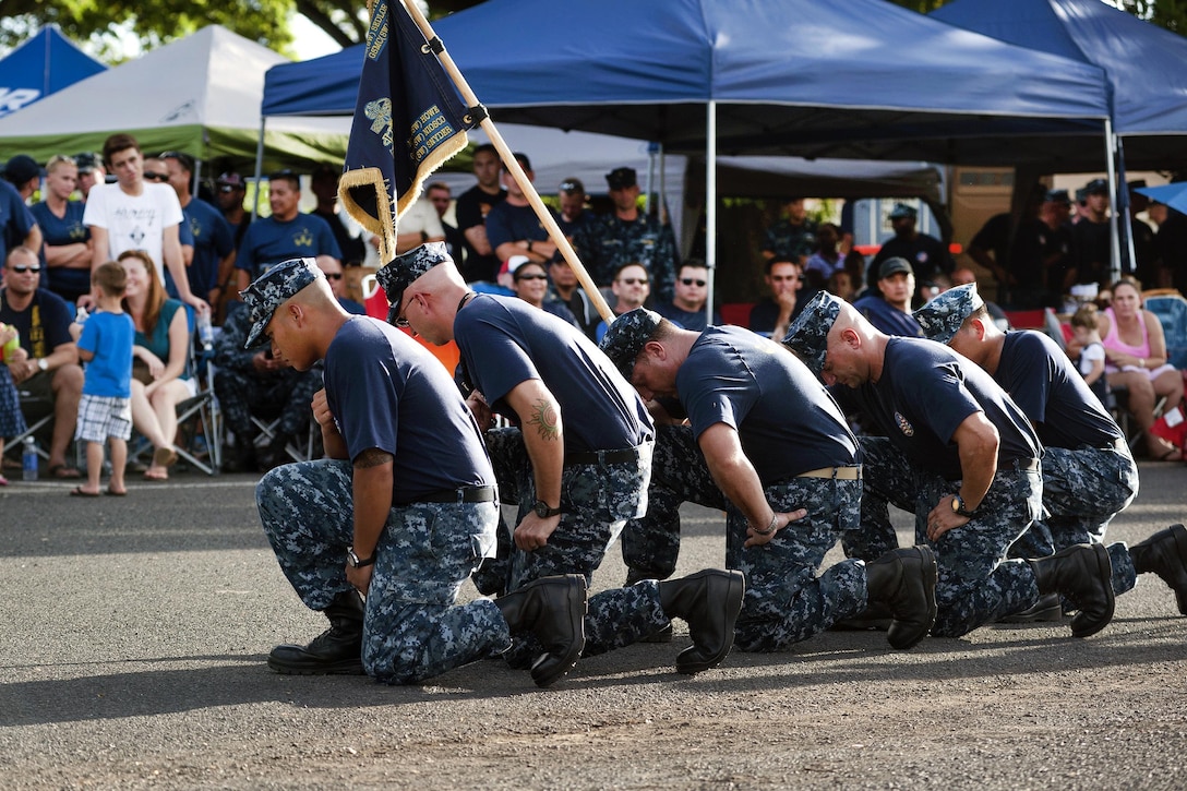 Navy chief petty officer selects kneel and observe a moment of silence in honor of the 14th anniversary of 9/11 during a Chief Petty Officer Pride Day event on Joint Base Pearl Harbor-Hickam, Hawaii, Sept. 10, 2015. U.S. Navy photo by Petty Officer 2nd Class Gabrielle Joyner
