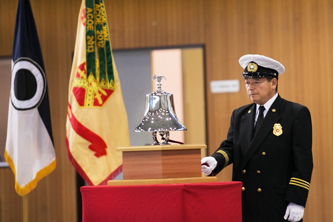 Kazuo Makino, U.S. Army Japan's deputy fire chief, rings a ceremonial firehouse bell during a 9/11 memorial ceremony on Camp Zama, Japan, Sept. 11, 2015. U.S. Army photo by Randall Baucom