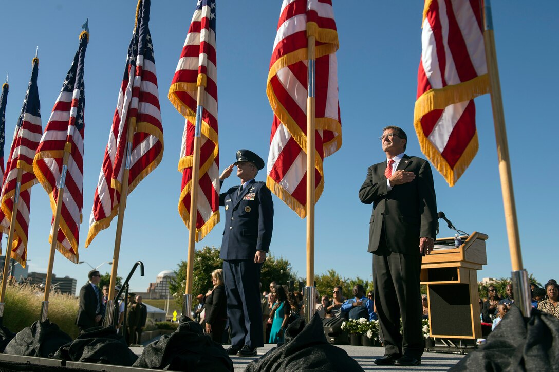 Defense Secretary Ash Carter and Air Force Gen. Paul J. Selva, vice chairman of the Joint Chiefs of Staff, render honors as the national anthem plays during a remembrance ceremony at the Pentagon Memorial, Sept. 11, 2015. Family members who lost loved ones attended the ceremony, which honored the memory of those killed in the 9/11 terrorist attack. DoD photo by U.S. Air Force Senior Master Sgt. Adrian Cadiz