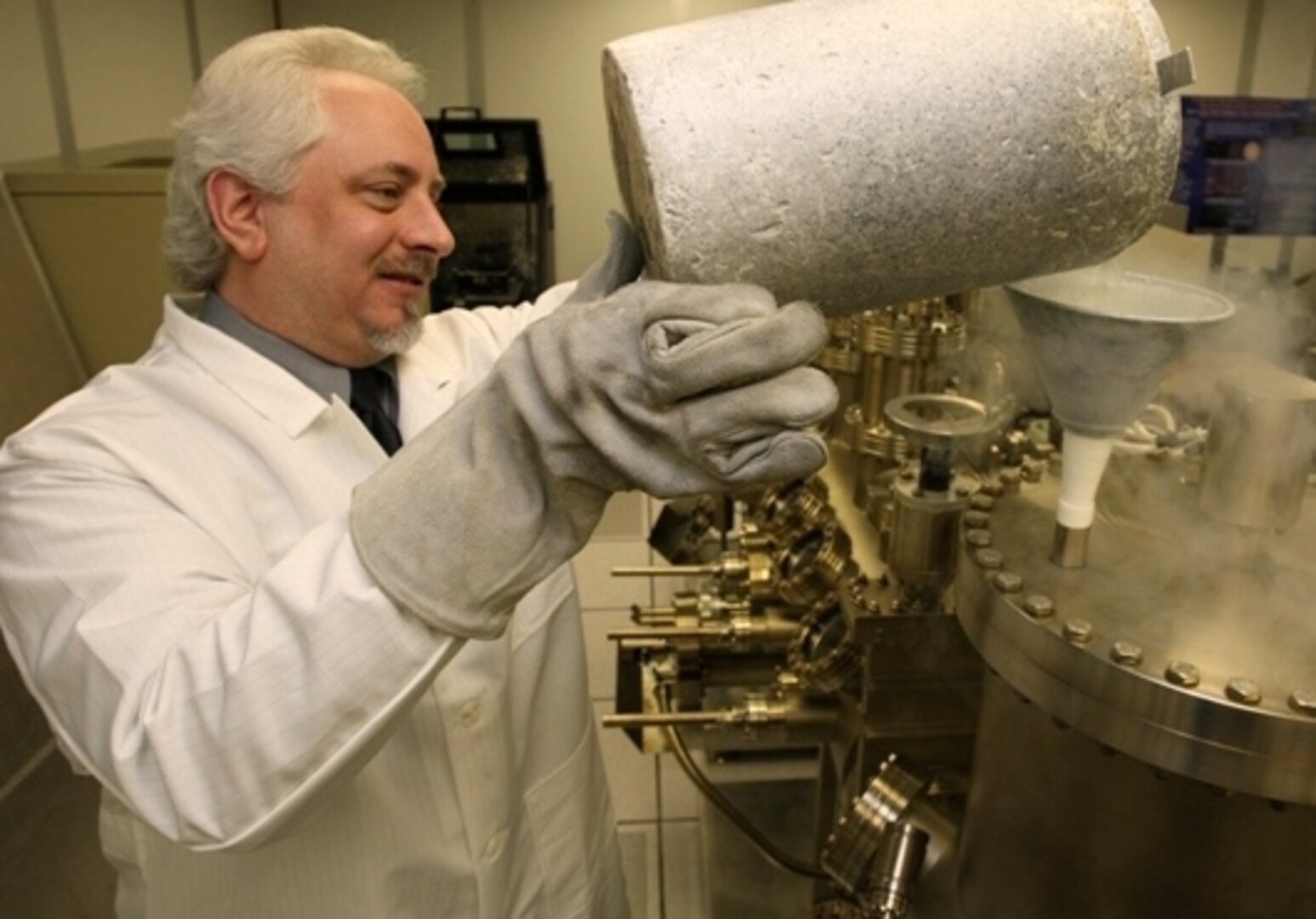 Naval Surface Warfare Center Dahlgren Division (NSWCDD) scientist Dr. Kevin Boulais uses liquid nitrogen in a molecular beam epitaxy system to create photo capacitors for light guide film applications.