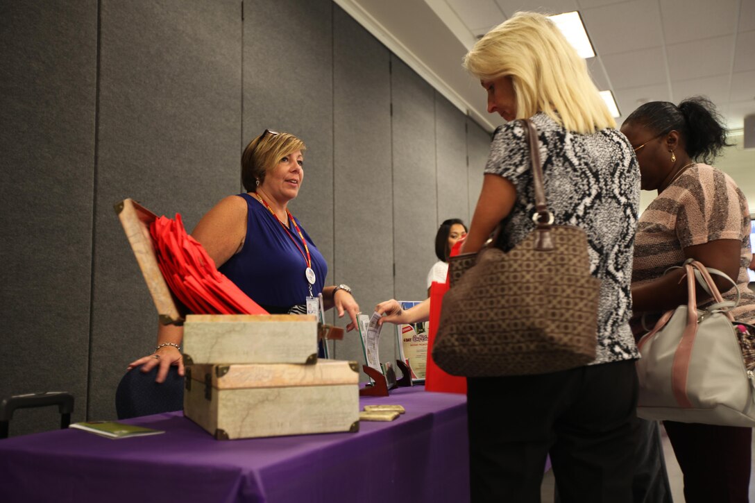 Dawn Preneveau, left, informs guests about available services during the Women’s Equality Day event held at Marine Corps Air Station Cherry Point, N.C., Sept. 2, 2015. Women’s Equality Day is a day to celebrate women’s right to vote which began with the signing of the 19th Amendment, Aug. 26, 1920. Preneveau is the travel consultant at Information, Tickets and Tours with Marine Corps Community Services at the air station. (U.S. Marine Corps photo by Pfc. Nicholas P. Baird/ released)
