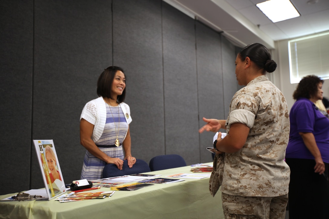 Desiree Satterfield showcases available family care programs during Women’s Equality Day at Marine Corps Air Station Cherry Point, N.C., Sept. 2, 2015. Women’s Equality Day is a day to celebrate women’s right to vote which began with the signing of the 19th Amendment, Aug. 26, 1920. Satterfield is the school liaison officer with Marine Corps Community Services at Marine Corps Air Station Cherry Point. (U.S. Marine Corps photo by Pfc. Nicholas P. Baird/ released)
