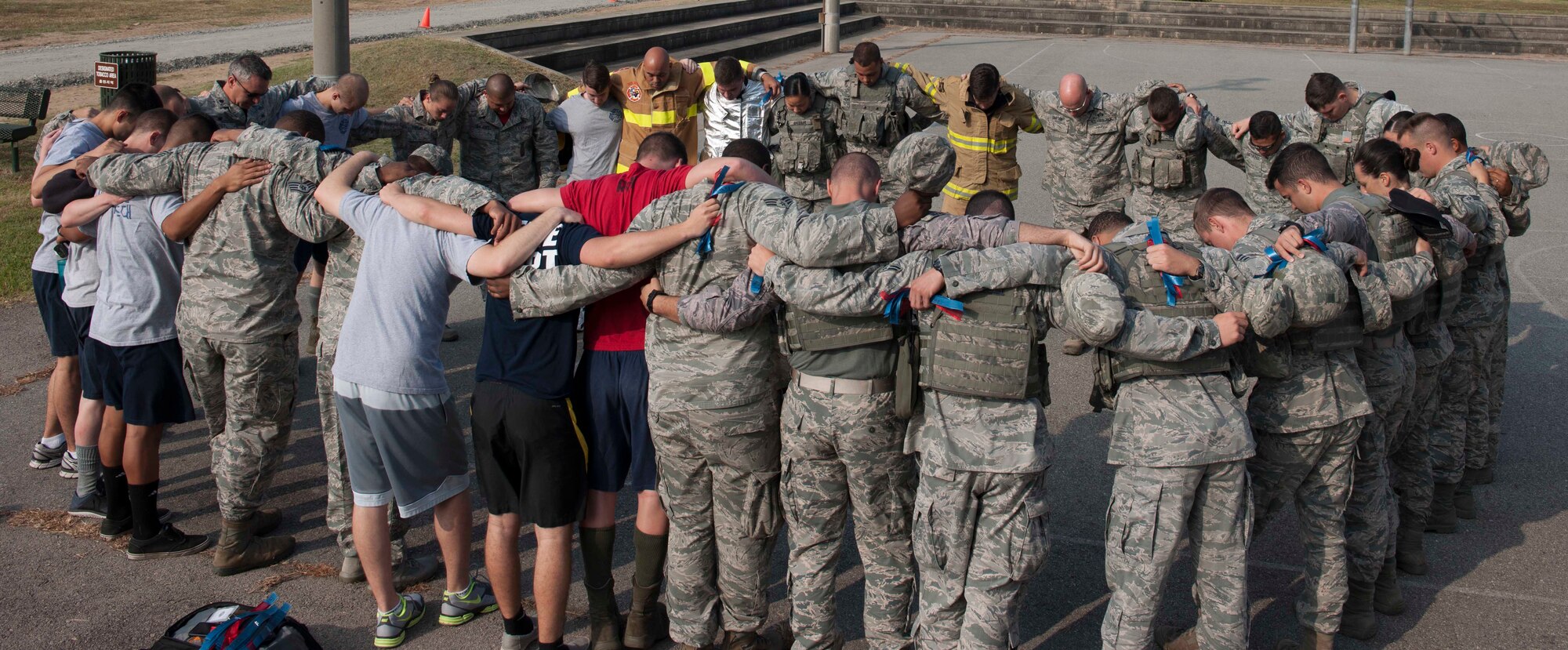 Members of the 8th Fighter Wing huddle together during a stair climb event in remembrance of 9-11 at Kunsan Air Base, Republic of Korea, Sept. 11, 2015. Airmen climbed steps to simulate the 110 stories first responders climbed at the World Trade Center on Sept. 11, 2001 (U.S. Air Force photo by Senior Airman Dustin King/Released)