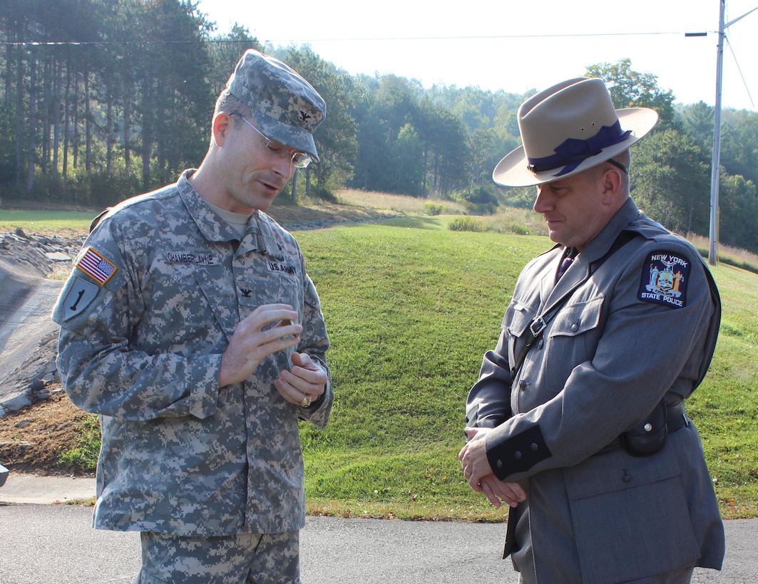 Col. Ed Chamberlayne, U.S. Army Corps of Engineers Baltimore District commander, honors New York State Trooper Donald Atkinson with a coin and certificate for rescuing a young girl at Whitney Point Dam.