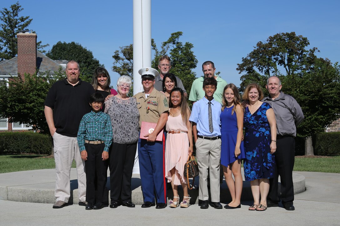 U.S. Marine Corps Master Sgt. Jay Wilfrom the adjutant chief for the 4th Marine Corps District and Pittsburgh, Pennsylvania native, poses with his and Loretta Marburger’s family after receiving his second Navy Marine Corps Medal at the Defense Distribution Center Susquehanna in New Cumberland, Pennsylvania, Sept. 11, 2015. Wilfrom received his second Navy Marine Corps Medal for rescuing Marburger from a fire that ended up destroying or damaging nine homes in Pittsburgh, Pennsylvania in June 2014.  He received his first in 1995 for saving a teenage military dependent from drowning in Iwakuni, Japan. (U.S. Marine Corps photo by Cpl. Tyler Birky/Released)