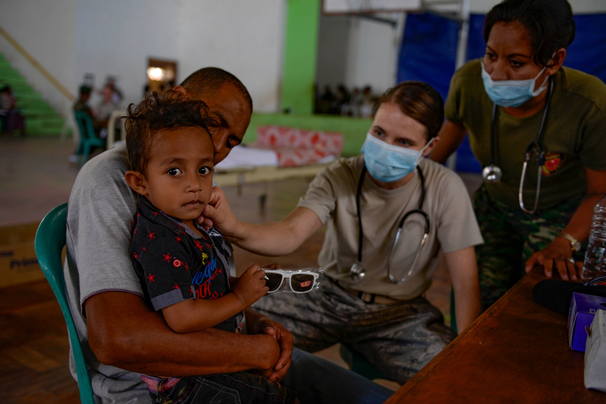 U.S. Air Force Maj. Shannon Brodersen, 141st Medical Group family practice physician, and Falintil Forças de Defesa de Timor-Leste 2nd Lt. Anabela De Cruz examine a young boy's skin condition during a Pacific Angel 15-2 healh services outreach Sept. 9, 2015, in Baucau, Timor-Leste. Pacific Angel is a multilateral humanitarian assistance civil military operation, which improves military-to-military partnerships in the Pacific while also providing medical health outreach, civic engineering projects and subject matter exchanges among partner forces. (U.S. Air Force photo by Staff Sgt. Alexander W. Riedel/Released)
