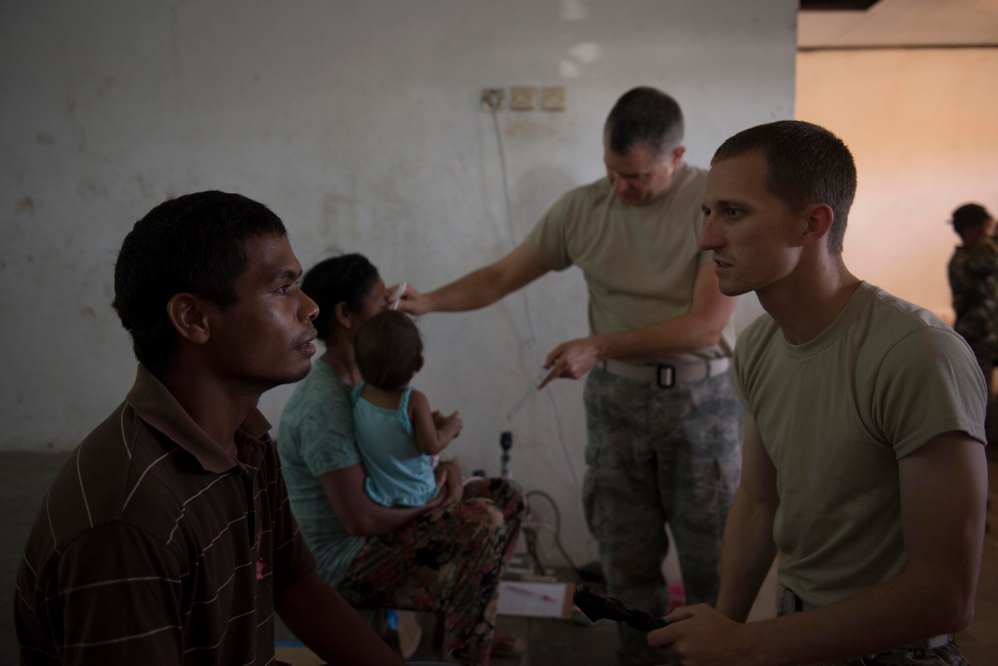 Capt. Davis Staley (front), 673rd Medical Group optometrist, and Master Sgt. Robert Shaw (back), 141st Medical Group optometry technician, examine patients during a Pacific Angel health services outreach Sept. 11, 2015, in Baucau, Timor-Leste. Pacific Angel is a multilateral humanitarian assistance civil military operation, which improves military-to-military partnerships in the Pacific while also providing medical health outreach, civic engineering projects and subject matter exchanges among partner forces. (U.S. Air Force photo by Staff Sgt. Alexander W. Riedel/Released)