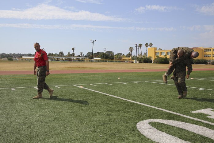 A recruit of Delta Company, 2nd Recruit Training Battalion, conducts a fireman’s carry with another recruit during the Combat Fitness Test at Marine Corps Recruit Depot San Diego, Sept. 9. The maneuver under fire is a course that covers 75 yards and also requires recruits to perform exercises such as sprints, ammunition can carries and throwing a simulated grenade at a marked target. Recruits were timed as they ran through the course and needed to finish it in less than 2 minutes and 14 seconds to receive 100 points. Today, all males recruited from west of the Mississippi are trained at MCRD San Diego. The depot is responsible for training more than 16,000 recruits annually. Delta Company is scheduled to graduate Nov. 13.